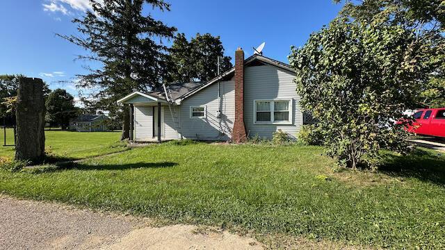 view of side of home with a yard