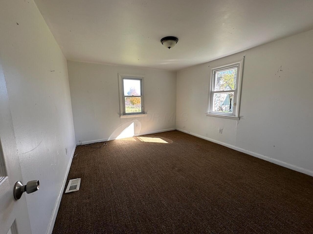 carpeted spare room featuring plenty of natural light