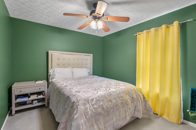 carpeted bedroom featuring ceiling fan and a textured ceiling