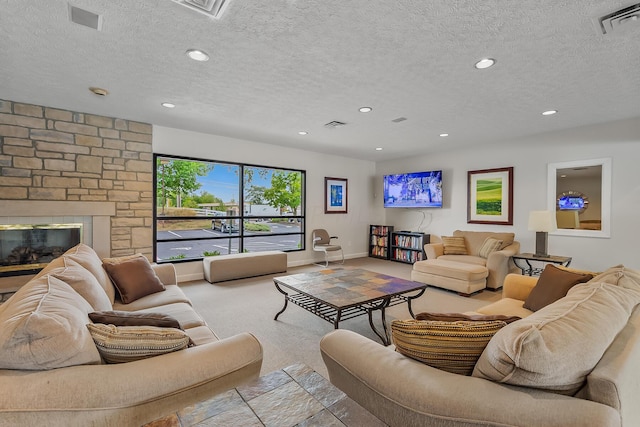 carpeted living room with a fireplace and a textured ceiling