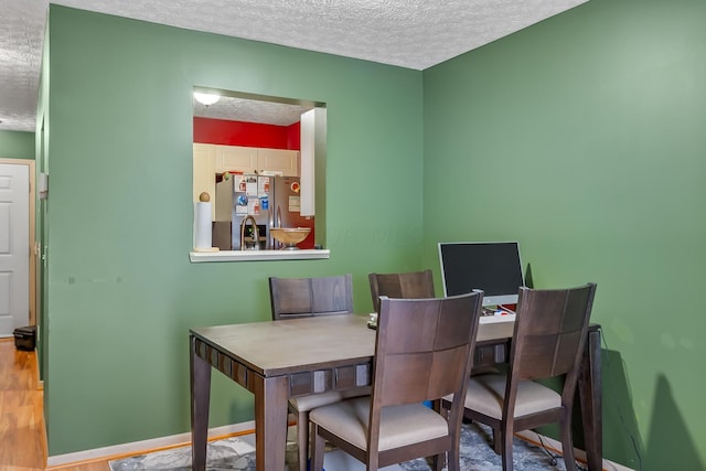 dining room with hardwood / wood-style flooring and a textured ceiling