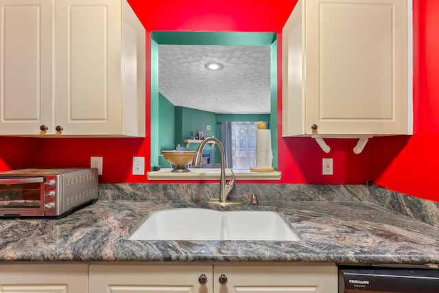 kitchen with dishwasher, a textured ceiling, and sink