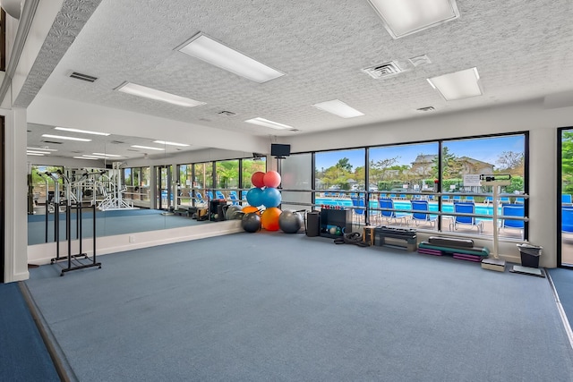 exercise room featuring carpet and a textured ceiling