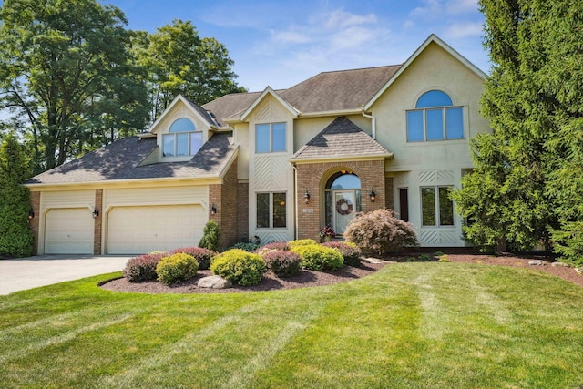 view of front of home featuring brick siding, a garage, and a front yard