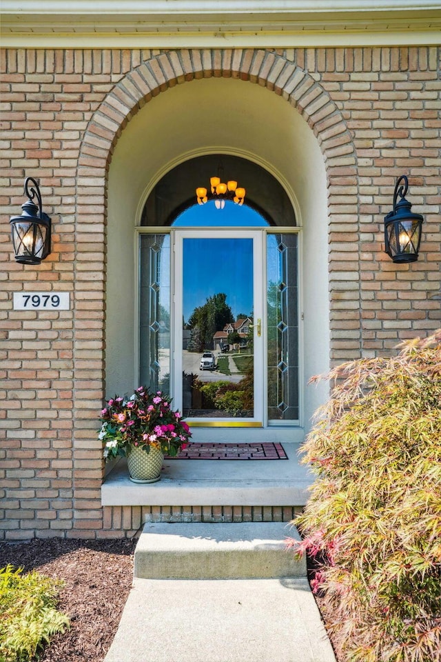 view of exterior entry with brick siding