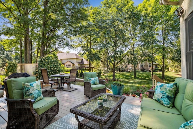 wooden terrace featuring outdoor dining space, an outdoor living space, and a yard