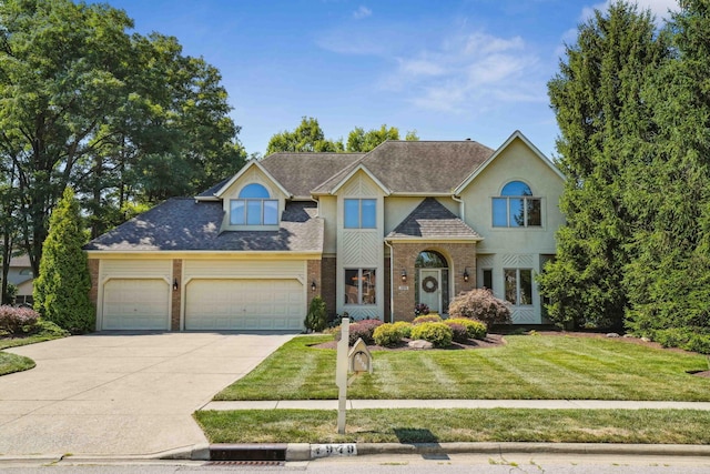 view of front of home featuring brick siding, concrete driveway, a front yard, stucco siding, and an attached garage