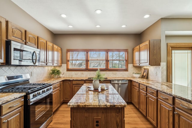 kitchen with light stone countertops, light wood finished floors, and stainless steel appliances