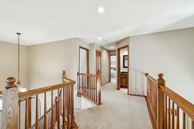 hallway with recessed lighting, an upstairs landing, light colored carpet, and baseboards