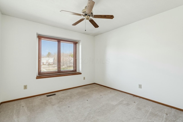 spare room featuring visible vents, baseboards, light colored carpet, and ceiling fan