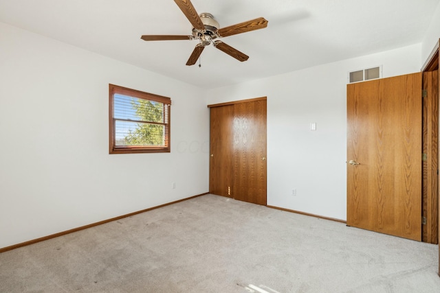 unfurnished bedroom featuring visible vents, a closet, carpet floors, baseboards, and ceiling fan