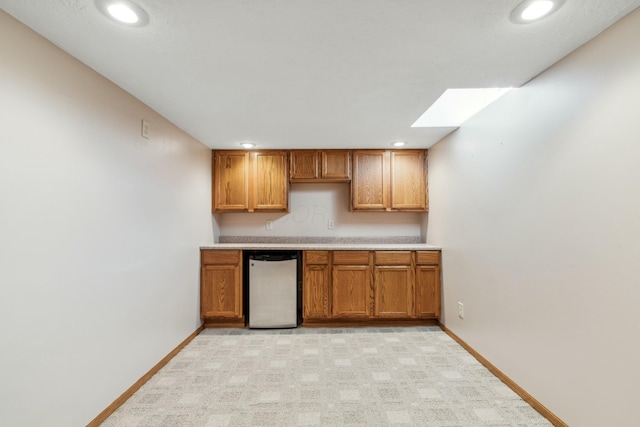 kitchen with light countertops, recessed lighting, brown cabinetry, and baseboards