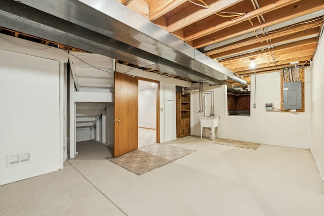 unfinished basement with electric panel, visible vents, and a sink