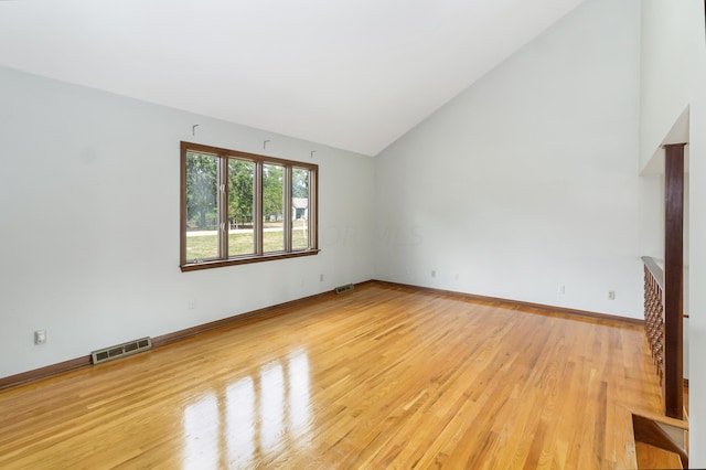 unfurnished living room with high vaulted ceiling and light hardwood / wood-style floors