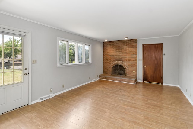 unfurnished living room with a fireplace, crown molding, plenty of natural light, and light hardwood / wood-style floors