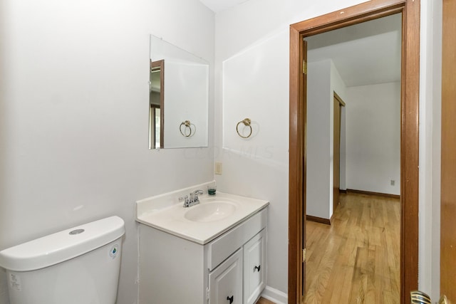 bathroom featuring vanity, hardwood / wood-style flooring, and toilet