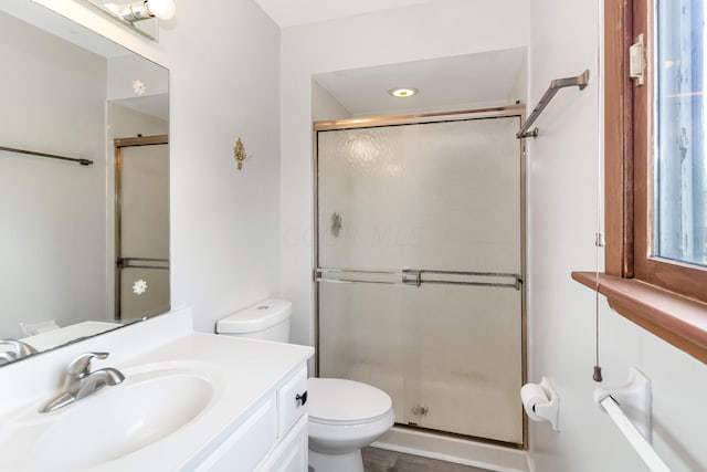 bathroom with vanity, toilet, and an enclosed shower