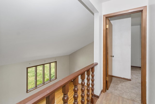 corridor with lofted ceiling and light hardwood / wood-style flooring