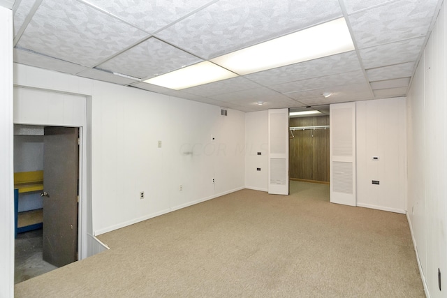 interior space featuring carpet flooring and a paneled ceiling