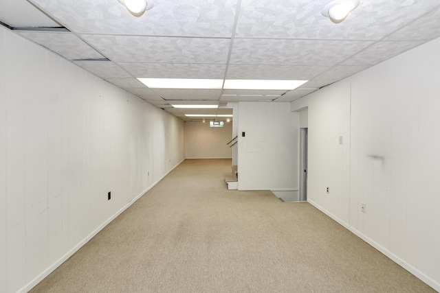 basement featuring light colored carpet and a drop ceiling