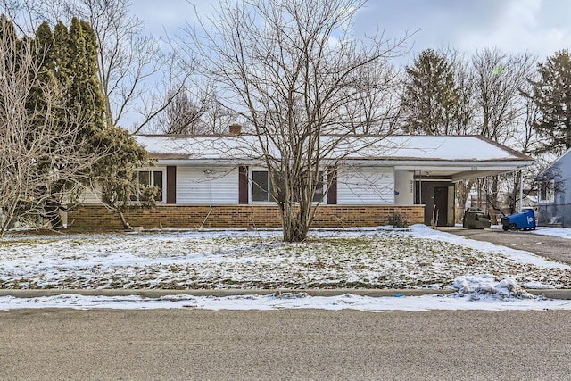 view of front of home featuring a carport and brick siding