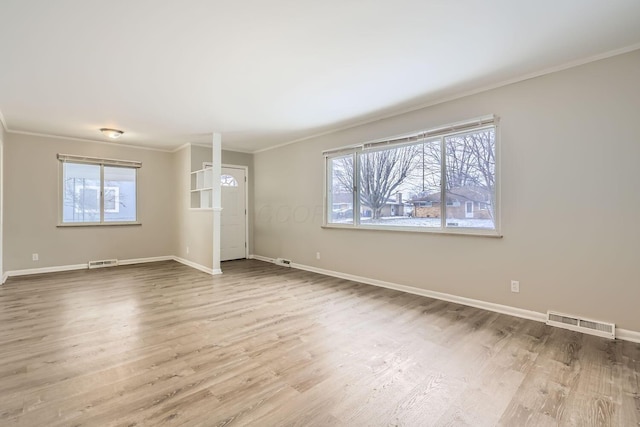 interior space with ornamental molding, visible vents, and wood finished floors