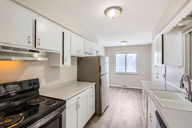 kitchen with electric range, visible vents, freestanding refrigerator, under cabinet range hood, and a sink