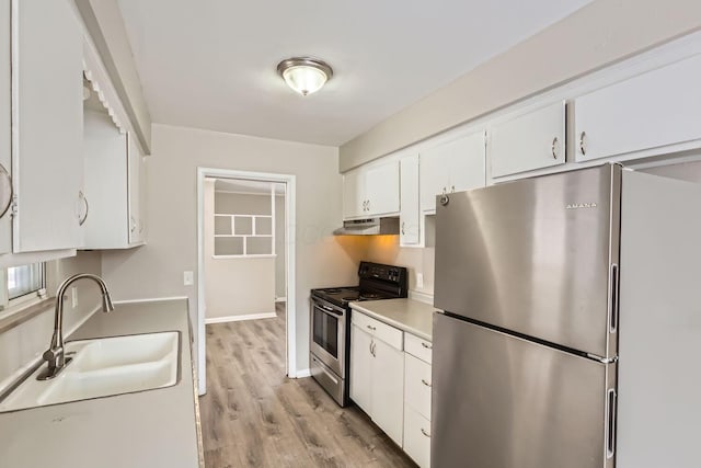 kitchen with stainless steel appliances, a sink, white cabinets, and under cabinet range hood