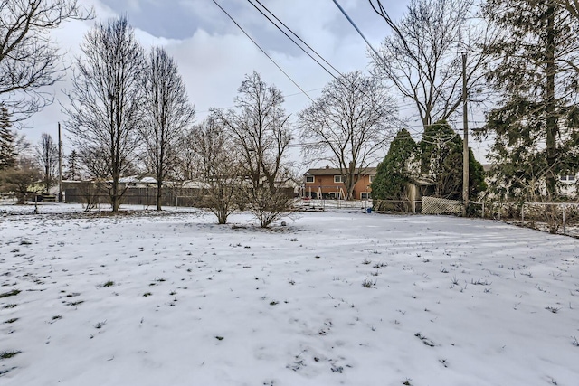 yard covered in snow featuring fence