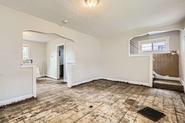 737 S Richardson Ave, Columbus, OH 43204 - unfurnished room with arched walkways, wood-type flooring, stairway, a textured ceiling, and a smoke detector