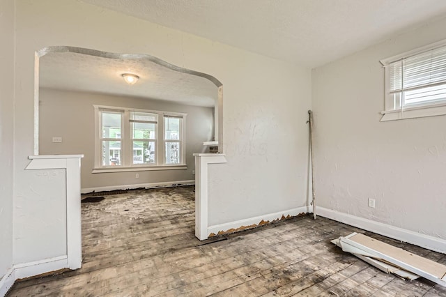 737 S Richardson Ave, Columbus, OH 43204 - unfurnished room featuring hardwood / wood-style floors, plenty of natural light, arched walkways, and a textured ceiling