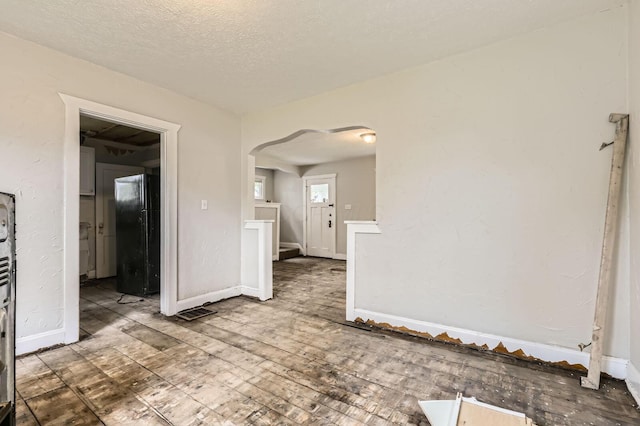 737 S Richardson Ave, Columbus, OH 43204 - unfurnished room with arched walkways, a textured ceiling, and hardwood / wood-style flooring
