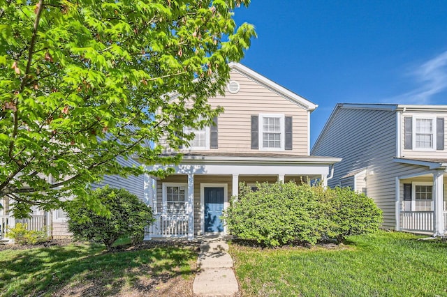 traditional-style house featuring a front lawn and covered porch