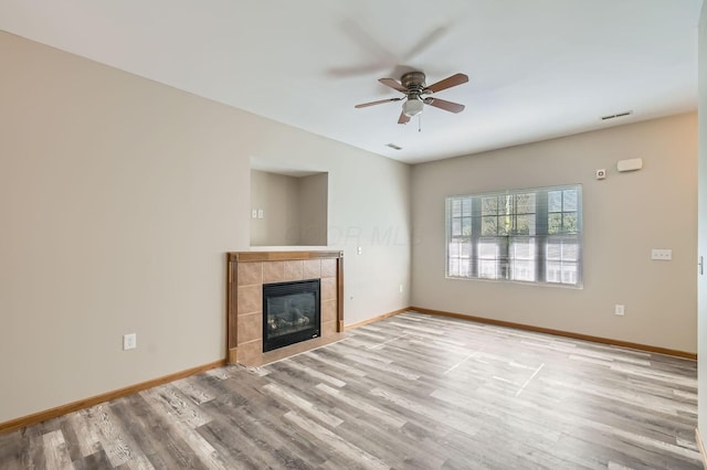 unfurnished living room featuring wood finished floors, baseboards, and ceiling fan