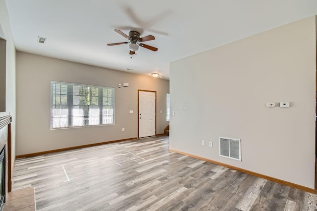 unfurnished living room with light wood-style floors, visible vents, baseboards, and ceiling fan