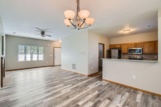 kitchen featuring brown cabinetry, appliances with stainless steel finishes, visible vents, baseboards, and light wood-style floors