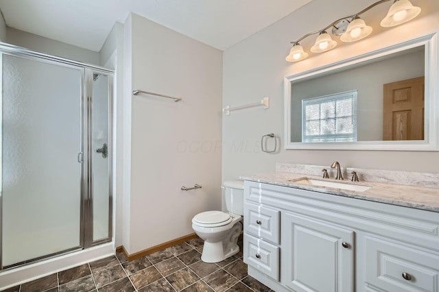 full bathroom with a stall shower, baseboards, vanity, and toilet
