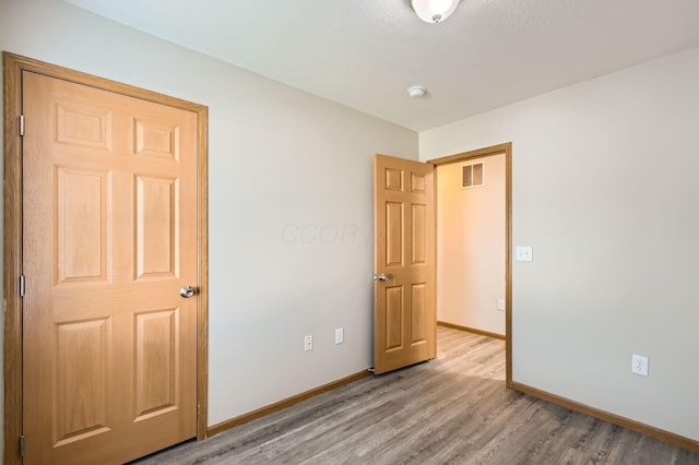unfurnished bedroom featuring light wood-type flooring, visible vents, and baseboards
