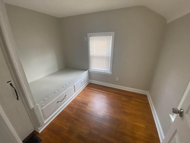 unfurnished bedroom featuring dark hardwood / wood-style floors and vaulted ceiling