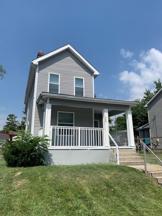 view of front of house featuring covered porch and a front lawn