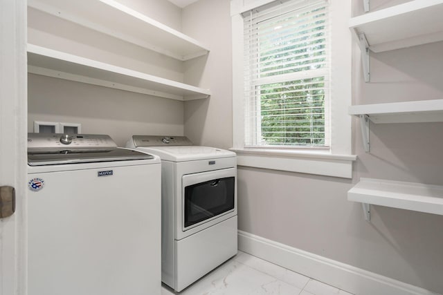 clothes washing area featuring washer and dryer and a wealth of natural light