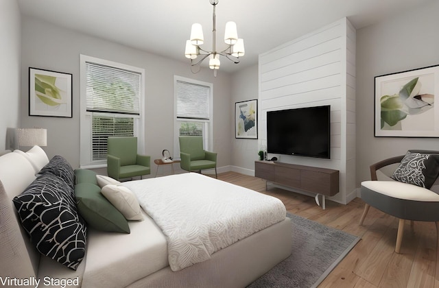 bedroom with light hardwood / wood-style flooring and an inviting chandelier