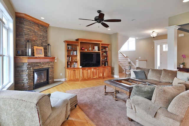 living room featuring a fireplace, light hardwood / wood-style flooring, and a wealth of natural light