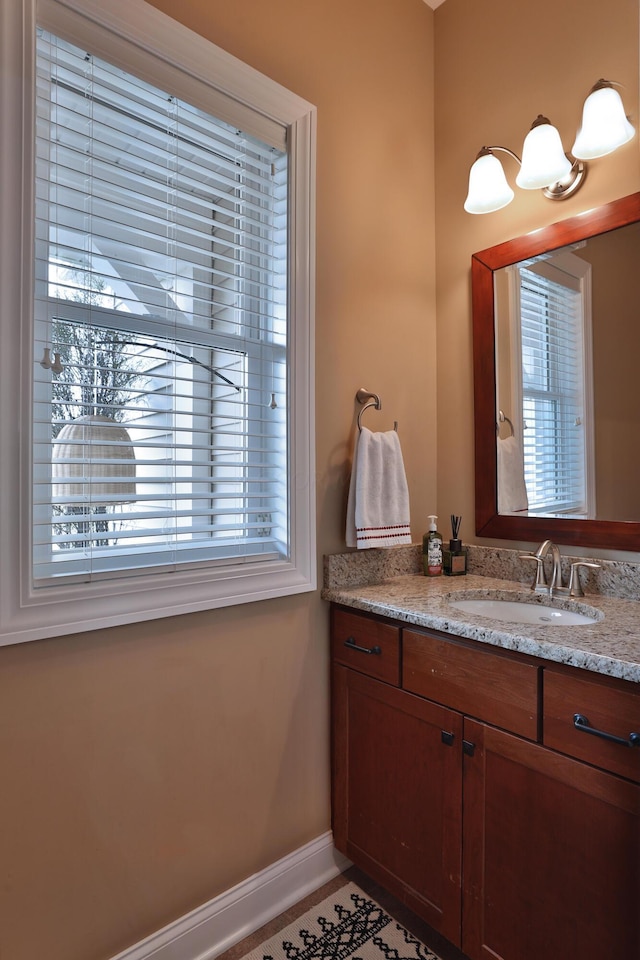 bathroom with tile patterned flooring, vanity, and a healthy amount of sunlight