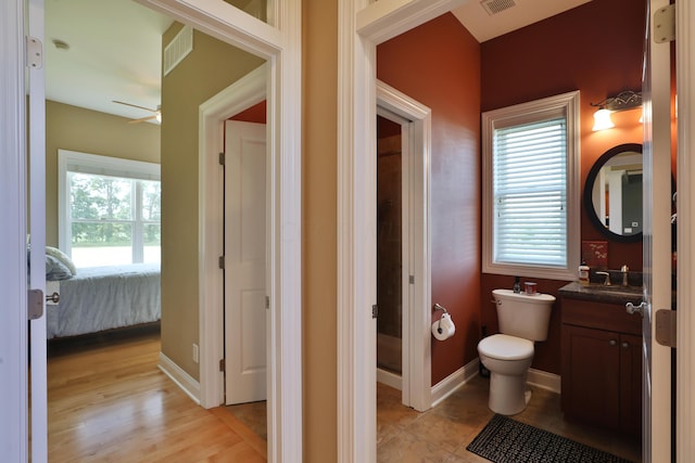 bathroom featuring plenty of natural light, toilet, wood-type flooring, and vanity