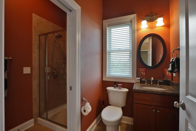 bathroom featuring tile patterned flooring, vanity, toilet, and a shower with door