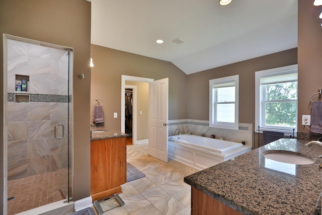 bathroom with vanity, lofted ceiling, and independent shower and bath