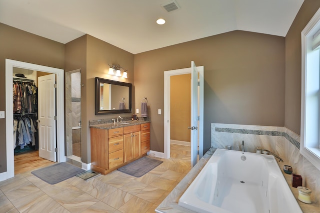 bathroom with separate shower and tub, vanity, and lofted ceiling