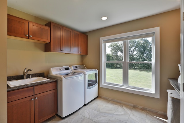 laundry area featuring cabinets, separate washer and dryer, and sink