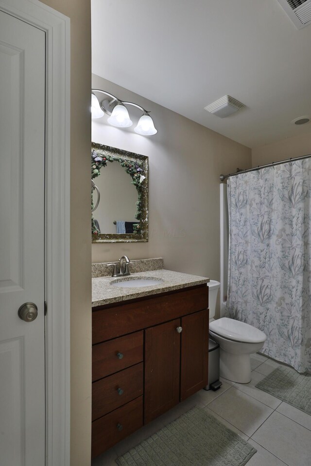 bathroom featuring tile patterned floors, vanity, a shower with shower curtain, and toilet